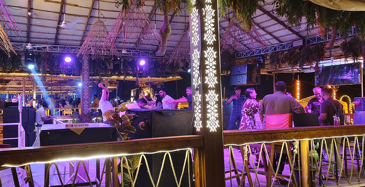 People enjoying music, dancing and nightlife at a beachside nightclub restaurant in Goa