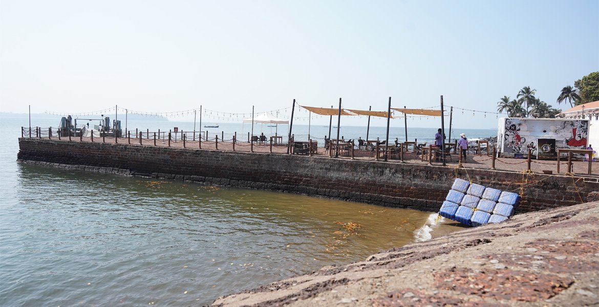 Goa waterfront promenade with a stone seawall, outdoor seating and views of the Arabian Sea