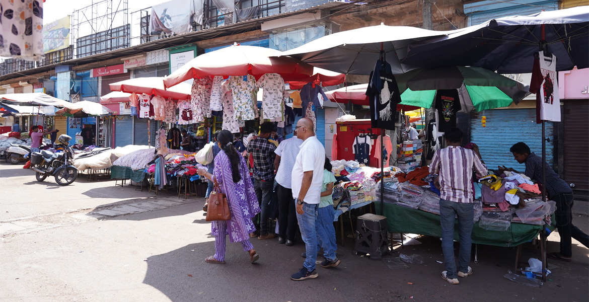 Goa shopping market with clothing stalls and shoppers