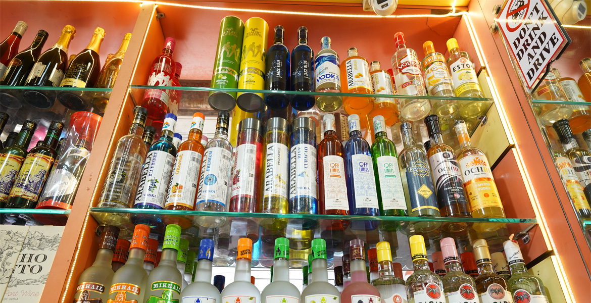Wine bottles displayed on shelves inside a Goa wine shop