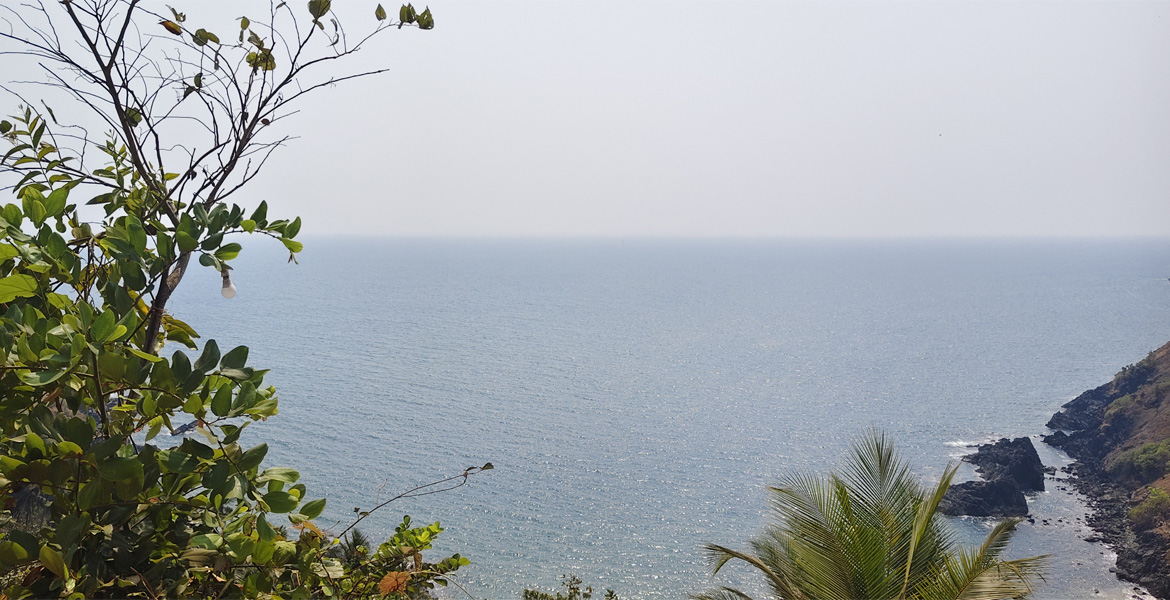 Ocean and rocky cliff at Kakolem Beach, Goa