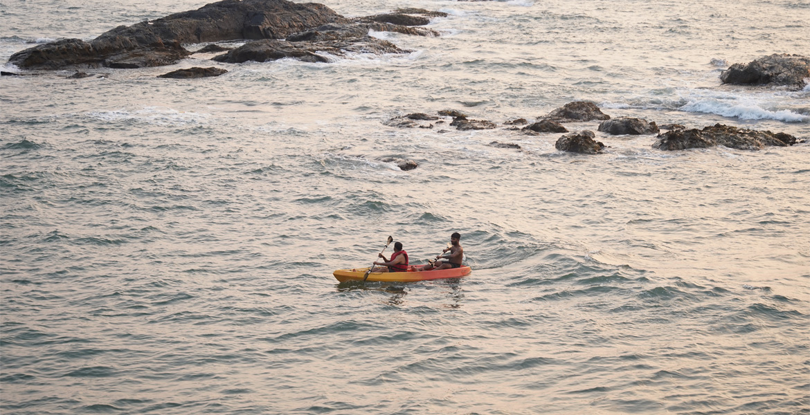Couple kayaking near rocky Goa coast