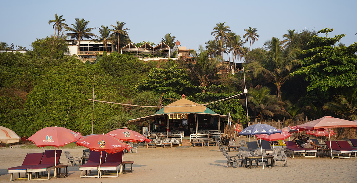 Beach shack with sun loungers and umbrellas near the shoreline in Goa