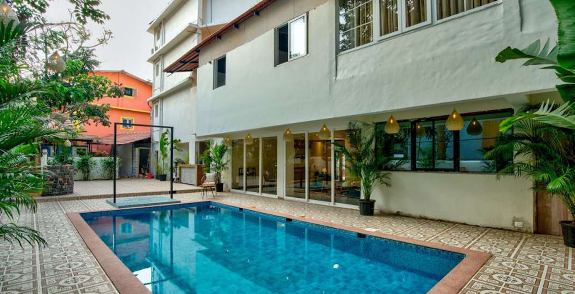 Modern luxury villa with a private swimming pool and tropical surroundings in Candolim, Goa.