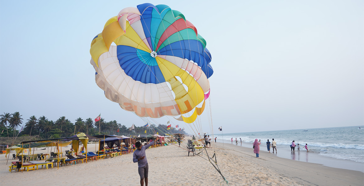 Colorful parasailing activity on the sandy shores of Majorda Beach Goa with visitors enjoying water sports