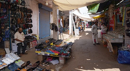 Mapusa Market street with footwear stalls and local vendors