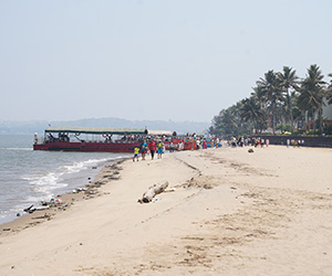 Visitors enjoying the sandy shoreline and scenic coastline at Miramar Beach in Panaji, Goa
