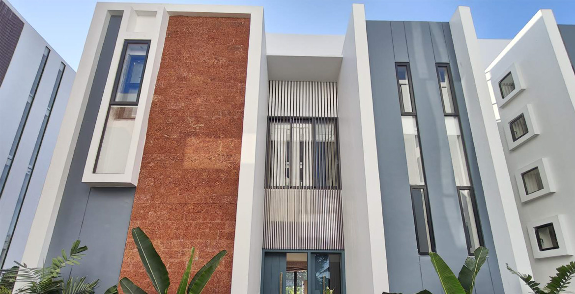 Modern luxury villa exterior with contemporary architecture, tall windows, textured wall design, and elegant facade in Goa