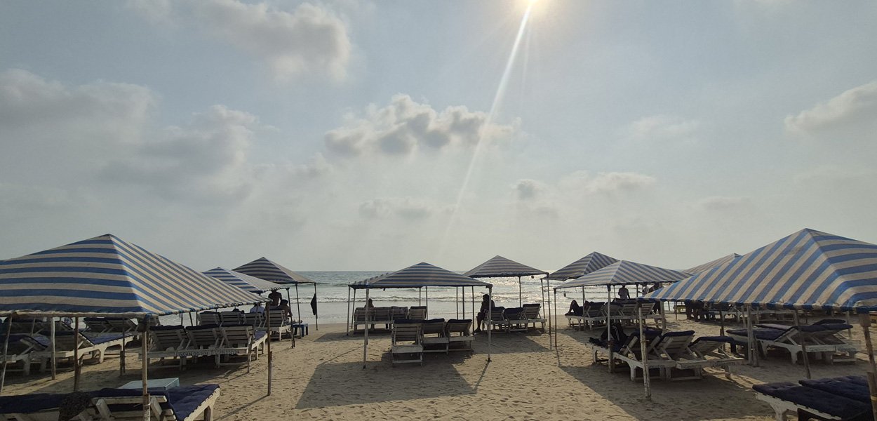 Morjim Beach Goa with striped beach umbrellas