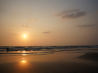 Sunset view at Ozran Beach in Goa with golden reflections on the shoreline
