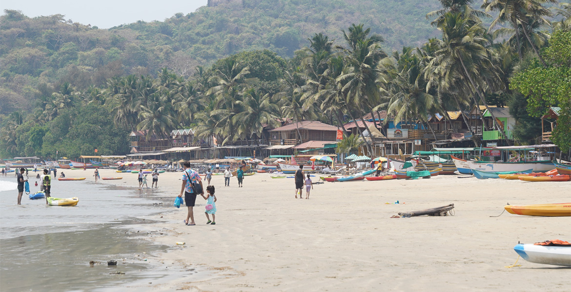 Palolem Beach Goa with palm trees, boats and visitors