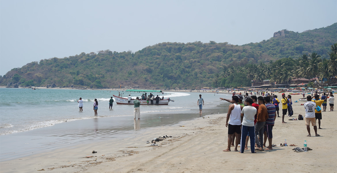 Visitors and fishing boat at Palolem Beach Goa