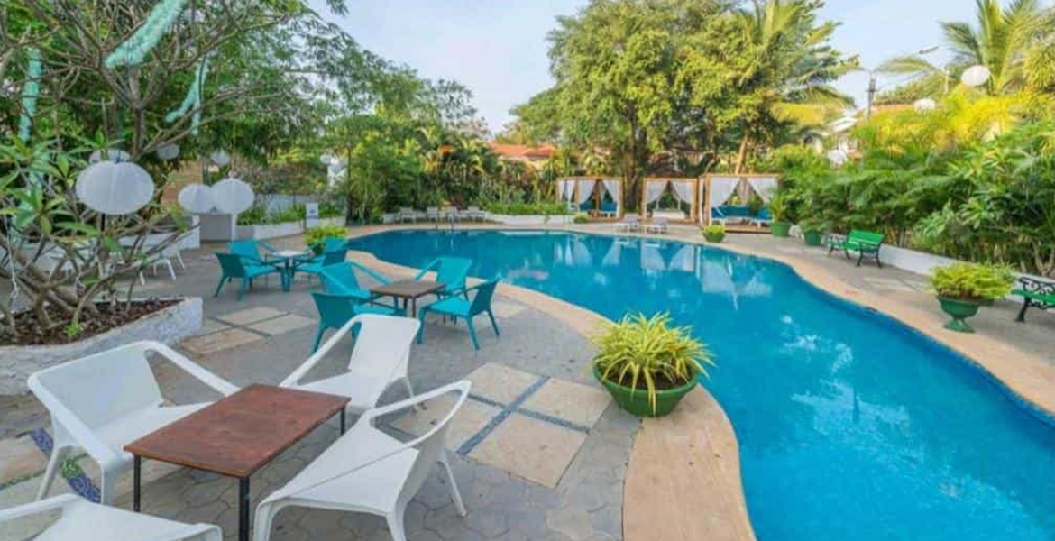 Luxury villa with a private swimming pool and outdoor seating area surrounded by tropical greenery in Goa