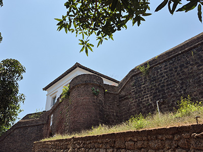 Stone walls of Reis Magos Fort under a clear blue sky