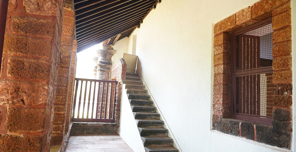 Historic corridor and stone staircase inside Se Cathedral in Old Goa
