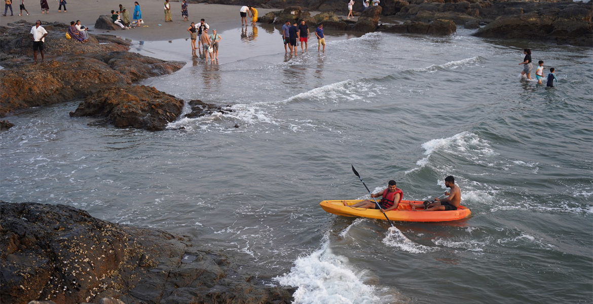 Kayakers paddling near rocky shoreline