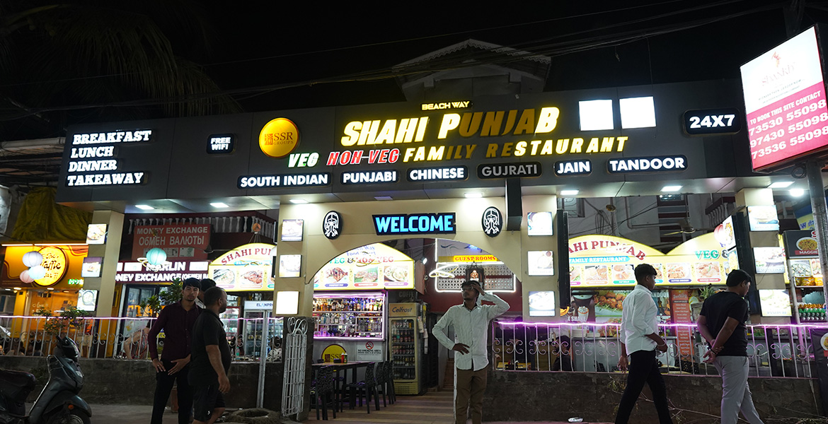 Shaahi Punjab restaurant at Baga Food Street in Goa illuminated at night with visitors outside