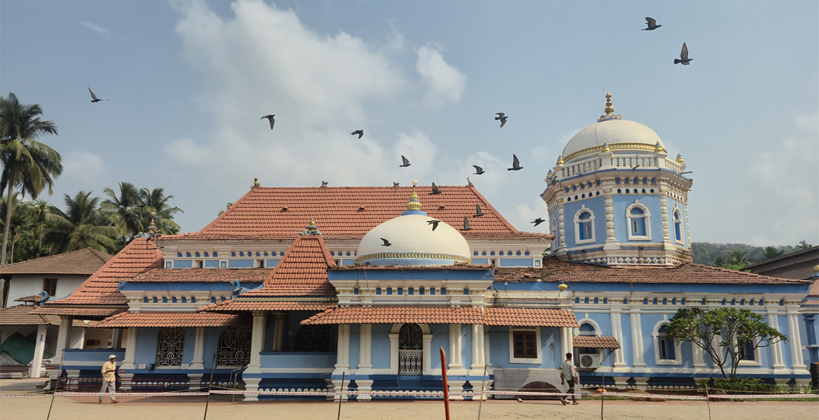 Shri Nageshi Temple in Bandora, Goa featuring its distinctive blue and white architecture, domes, and traditional Hindu temple design