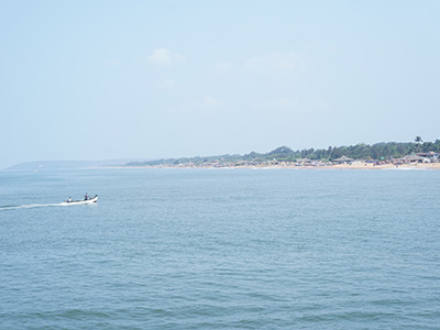 Scenic sea view of Sinquerim Beach in Goa with coastline and boat in the Arabian Sea