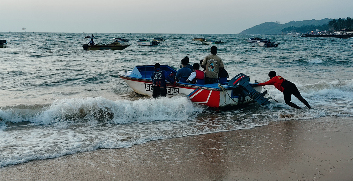 People launching a speed boat from a Goa beach