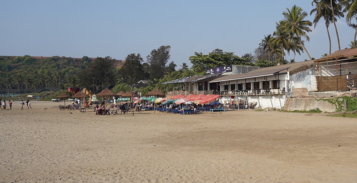 Beach restaurants, shacks and seating area along the sandy shoreline at Vagator Beach, Goa