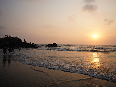 Sunset view with sea waves and rocky shoreline at Vagator Beach in Goa