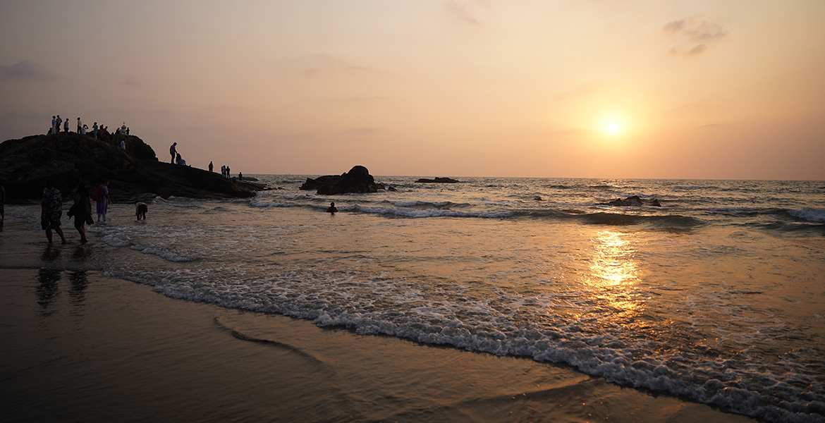 Sunset view with waves and rocky shoreline at Vagator Beach in Goa