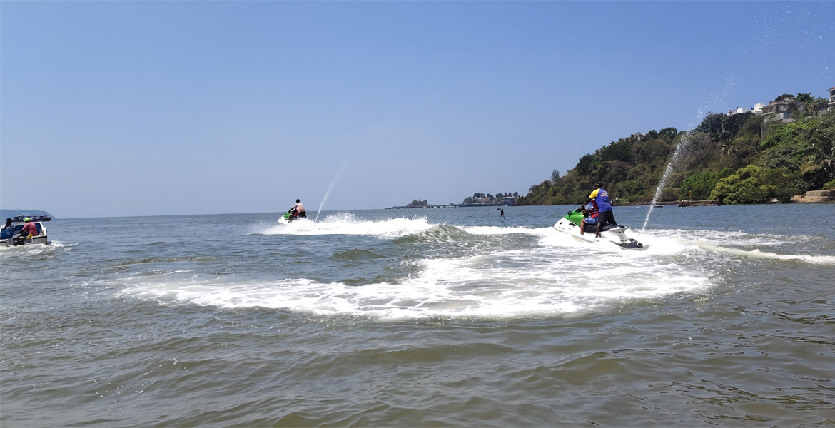 People enjoying jet ski water sports activities at Vainguinim Beach in Goa