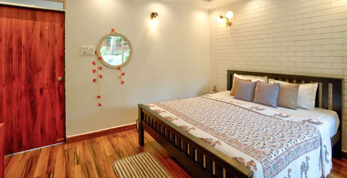 Modern villa bedroom interior with wooden flooring and king-size bed in Goa