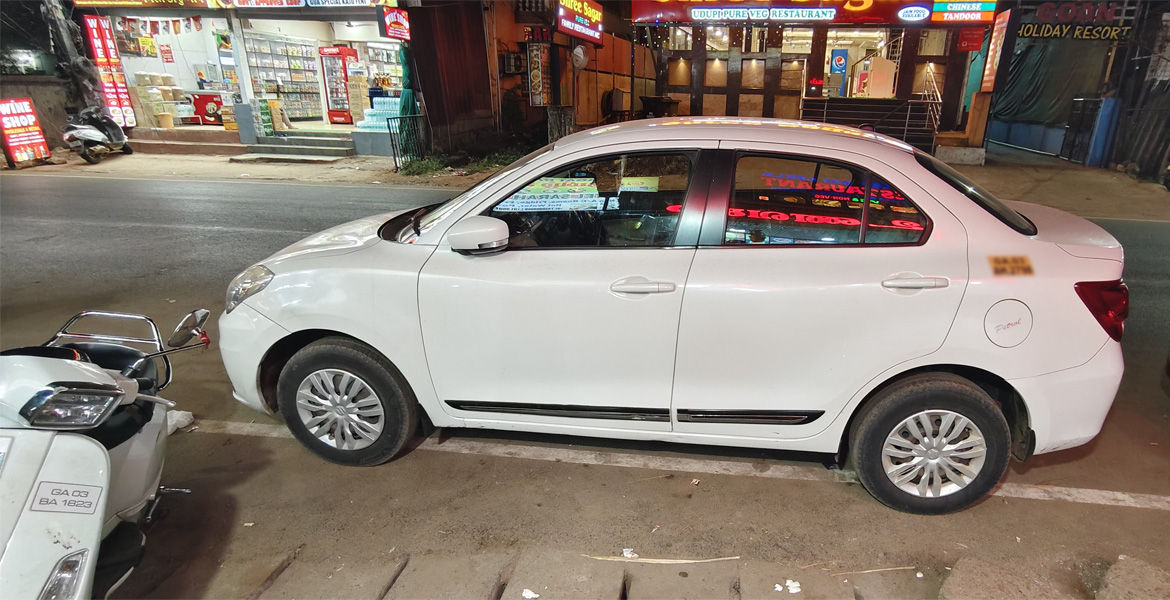 White taxi parked on a Goa roadside