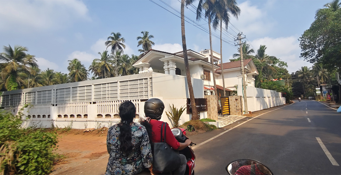 Women riding a scooter on a Goa road