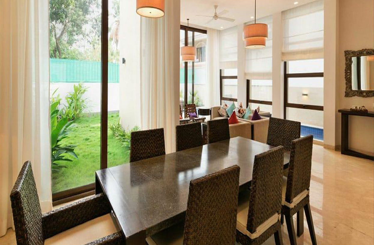 Bright dining room overlooking a lush green garden