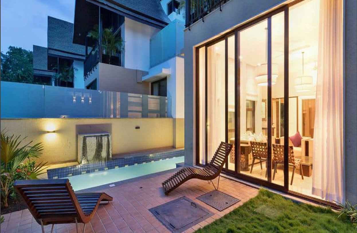Outdoor lounge area with poolside seating and large glass doors