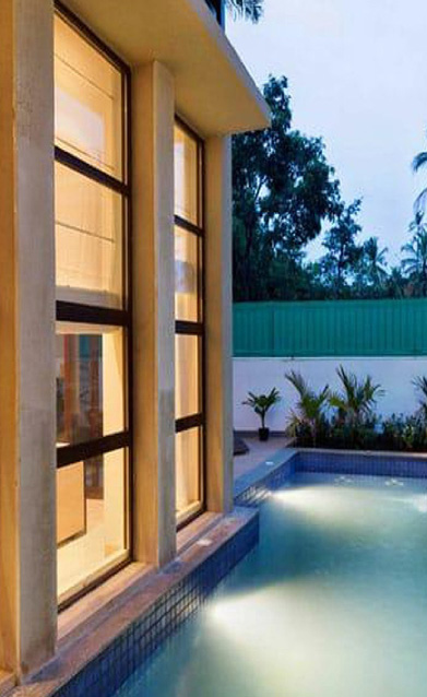 Cozy poolside view with tall windows and ambient evening lighting