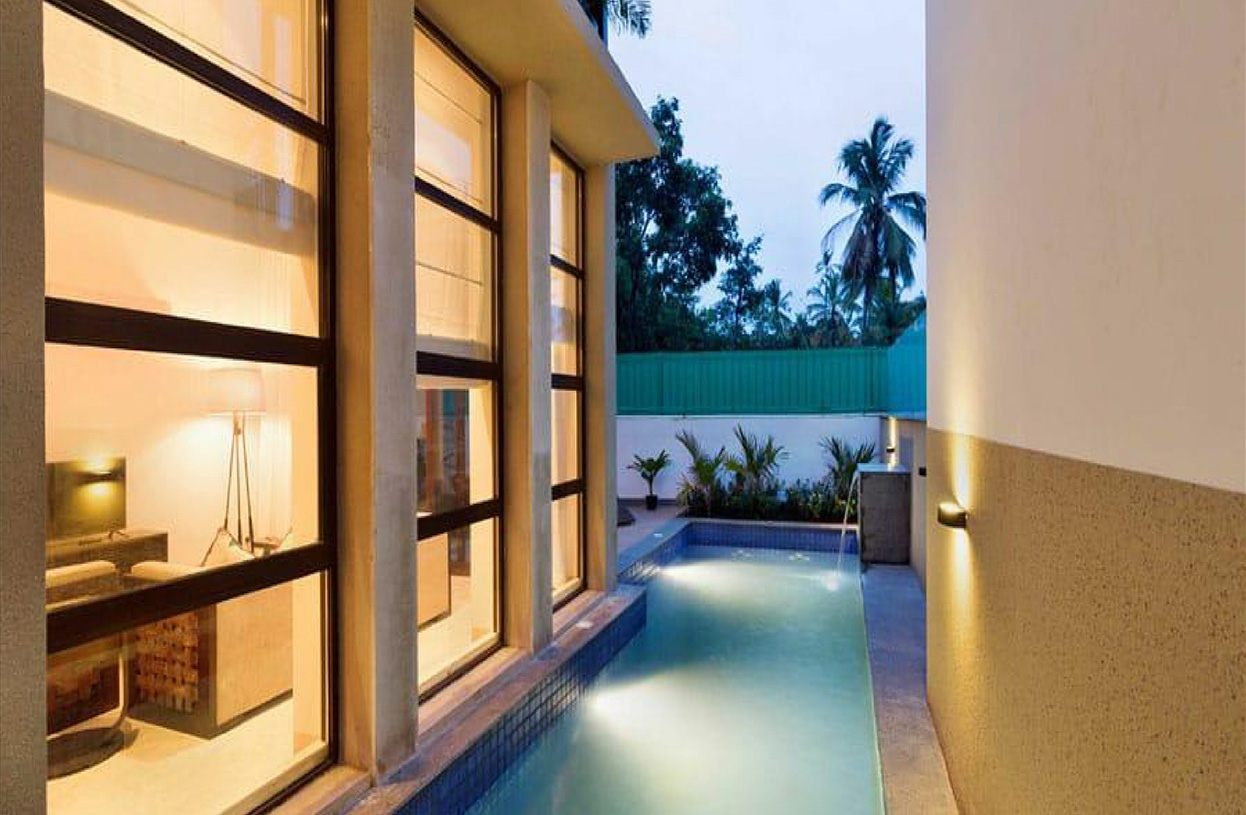 Evening poolside scene with illuminated water and garden plants