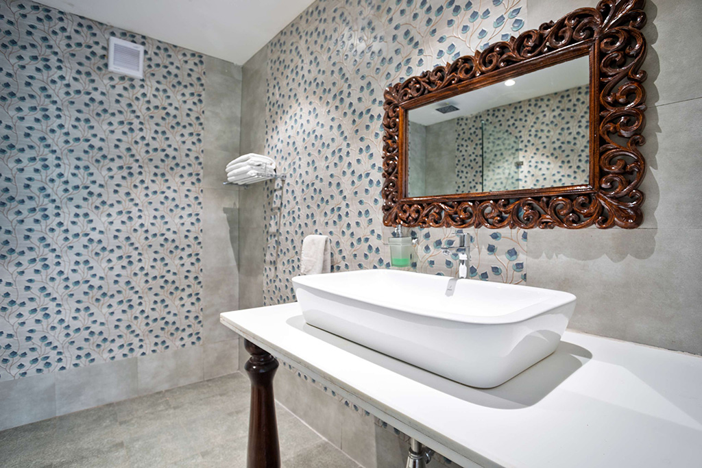 Bathroom with blue patterned accent wall and rectangular vessel sink