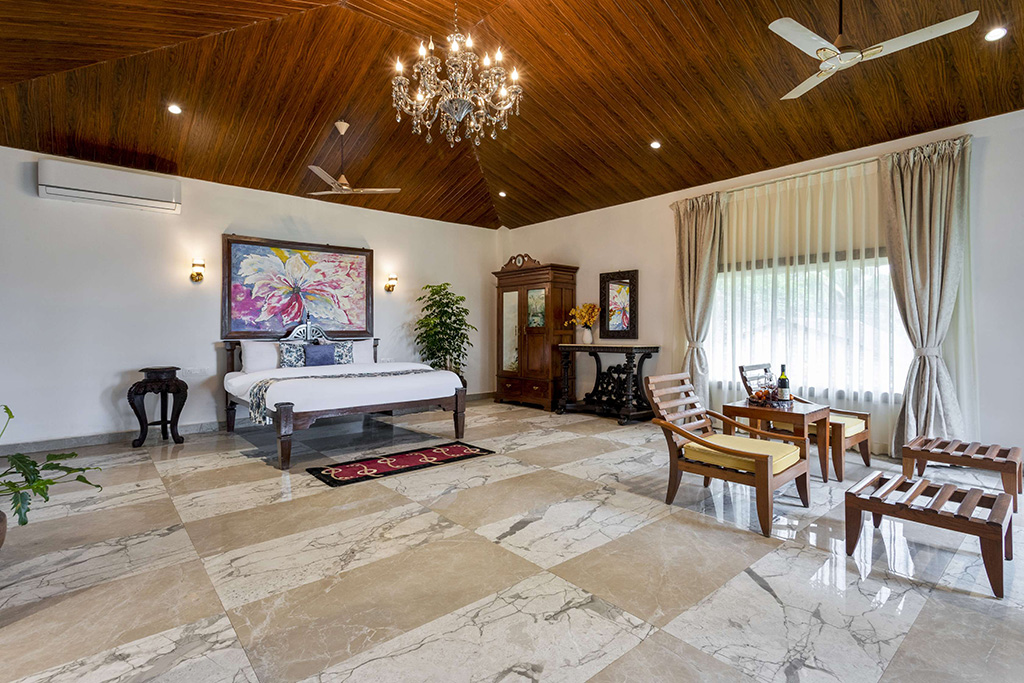 Bedroom with wood ceiling, marble floor, and sitting area by windows