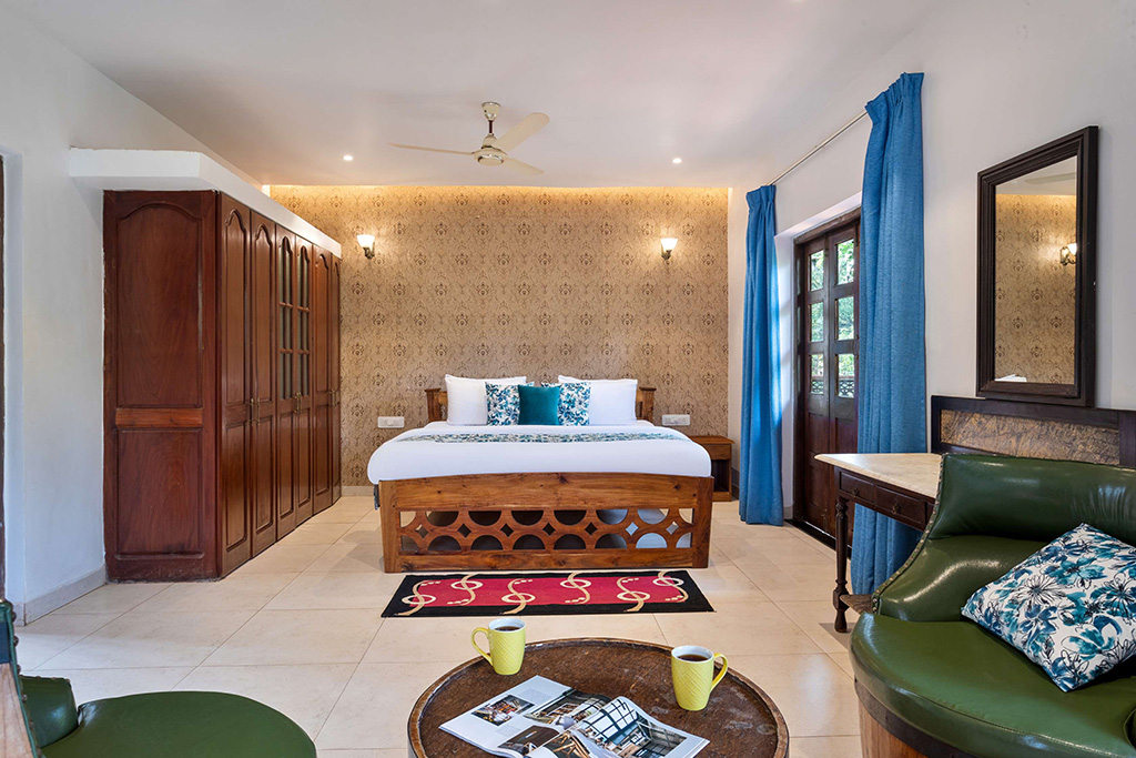 Bedroom with wooden bed, green leather chair, and dark wood furniture
