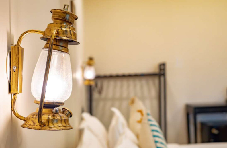 Decorative vintage wall lamp beside bed in luxury Goa villa bedroom