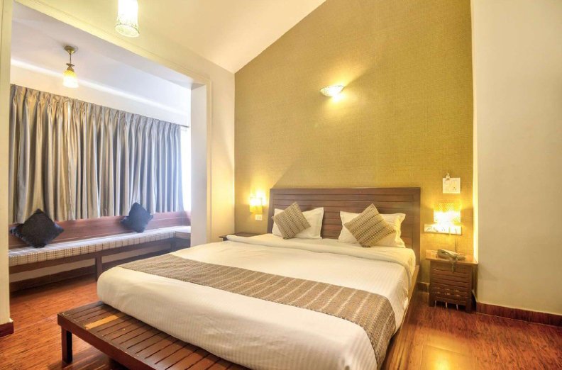 Bedroom with double bed, wooden floor and window seating area