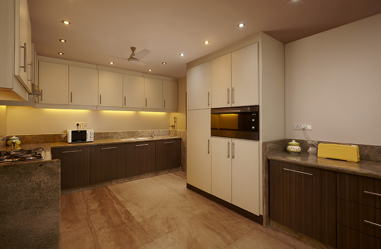 Modern modular kitchen with ample storage, built-in appliances, and warm under-cabinet lighting at Dolphin Heights