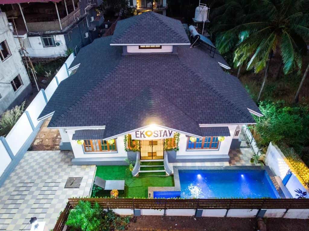 A stylish property featuring a private pool, elegant exterior lighting, and a peaceful setting