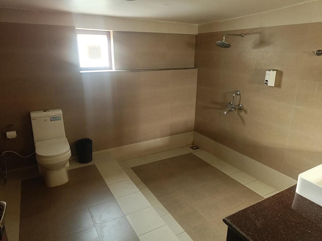 Spacious bathroom with shower, toilet, and sink.