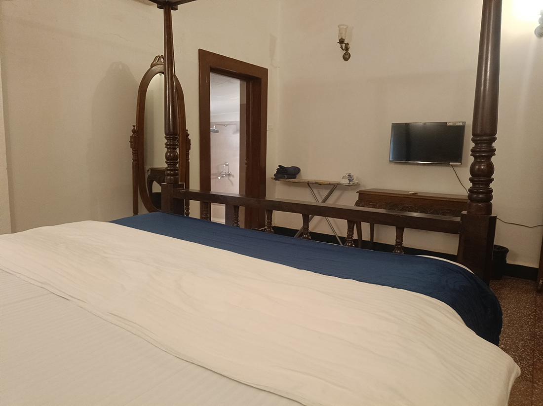 Bedroom with a four-poster bed and mirrored wardrobe.
