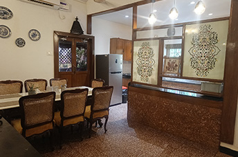 Goa villa dining area with classic wooden furniture and open kitchen