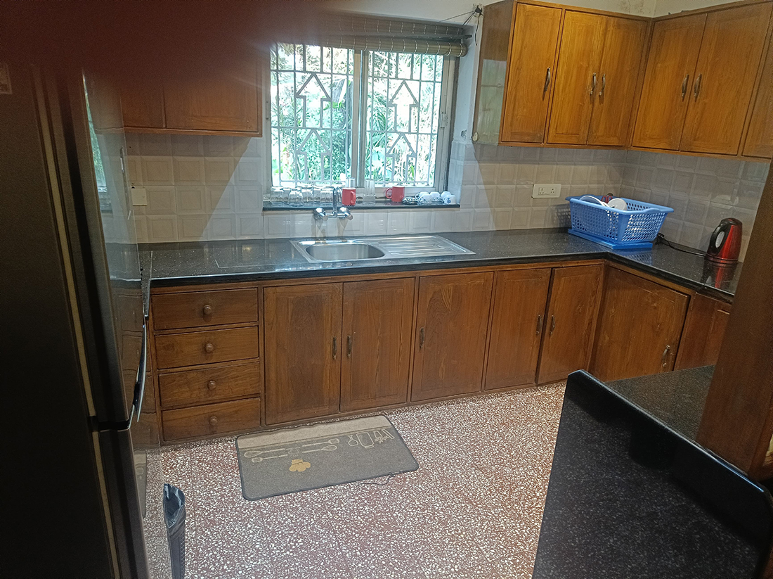 Kitchen with wooden cabinets, sink, and window.