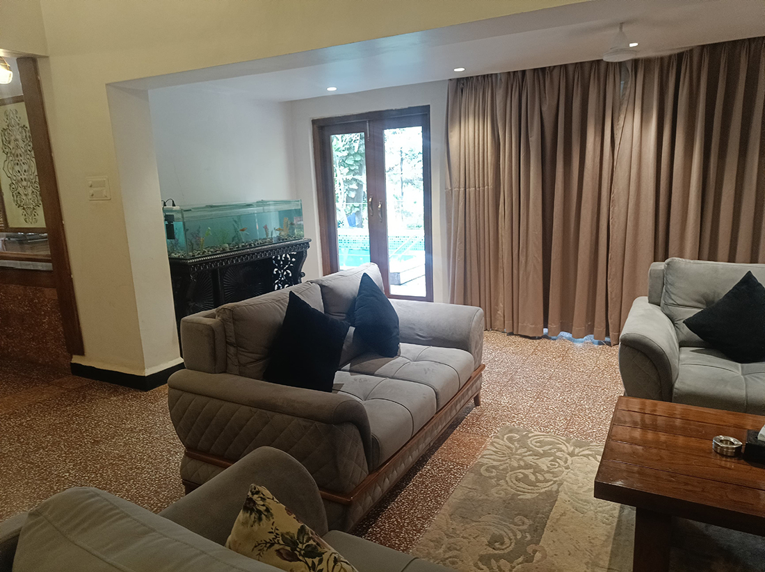 Living room with sofas, aquarium, and doors to pool area