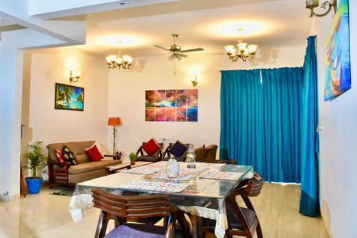 Living and dining room with bright lighting and blue curtains