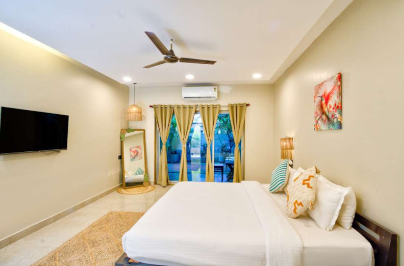 Spacious AC bedroom with balcony view in Morjim luxury villa