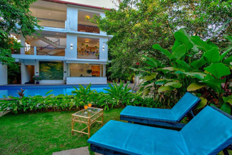 Garden lounge chairs facing private pool at Morjim luxury villa